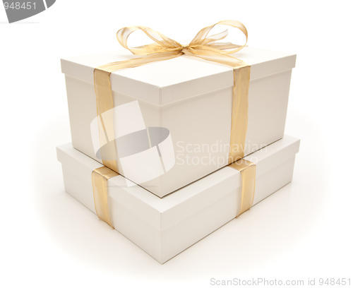 Image of Stacked White Gift Boxes with Gold Ribbon Isolated