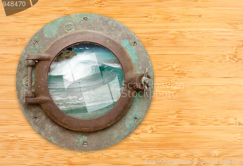 Image of Antique Porthole with View of Crashing Waves on a Bamboo Wall Ba