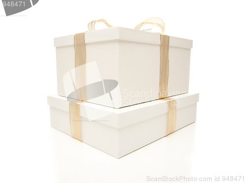 Image of Stacked White Gift Boxes with Gold Ribbon Isolated
