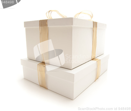 Image of Stacked White Gift Boxes with Gold Ribbon Isolated