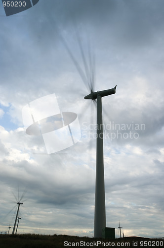 Image of Wind turbines spinning fast on windy day