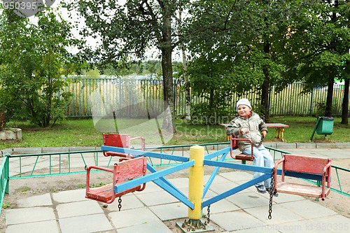 Image of Little smiling boy on rolling swing