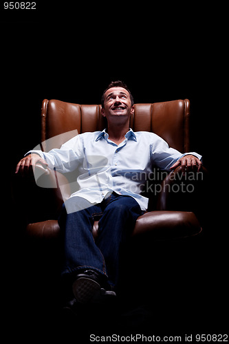 Image of Man smiling and looking up seated on a chair