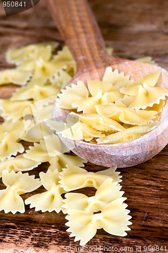 Image of uncooked pasta in wooden spoon