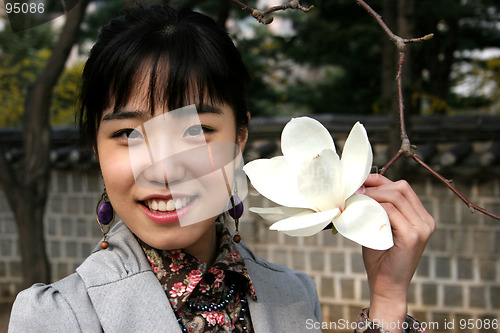 Image of Pretty Korean woman holding a flower