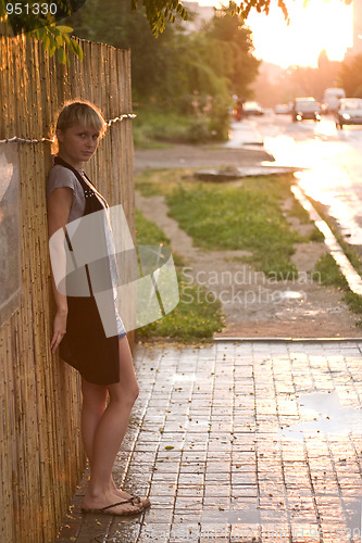 Image of City girl staniding against the wall