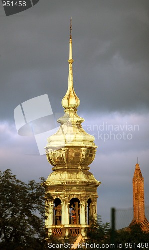 Image of Golden tower of the church in the cloudy sky