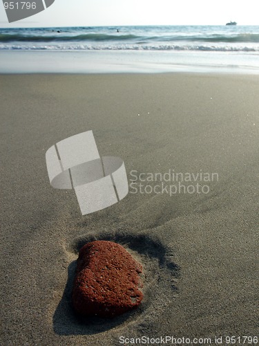 Image of Red stone in the sand after ebb in Puerto Escondido, Mexico