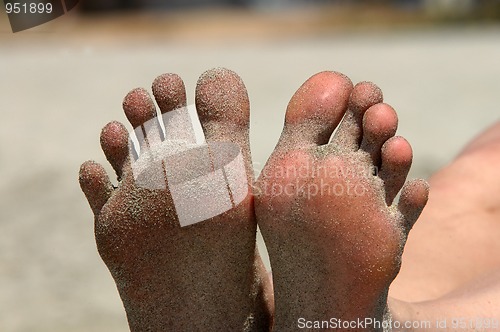 Image of Feet of woman lying on the beach