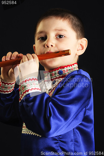 Image of Little kid playing wooden flute