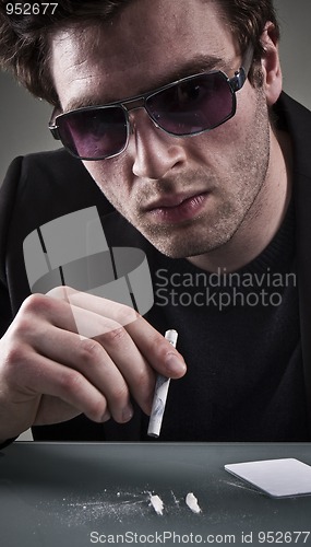 Image of Young man sniffing cocaine.