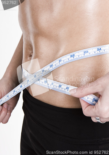 Image of measuring tape around slim beautiful waist