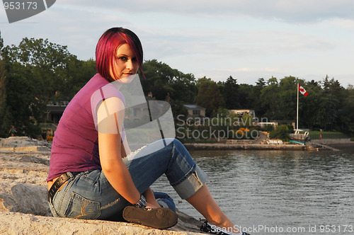 Image of Girl ssitting on lakeshore.