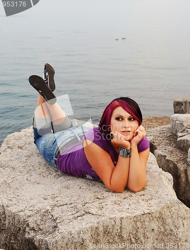 Image of Girl lying on lakeshore.