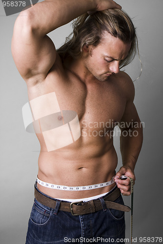 Image of Muscular man measuring his waist