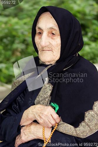 Image of Elderly woman with beads looking sideways