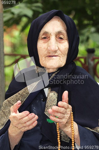 Image of Elderly woman with beads gesticulating