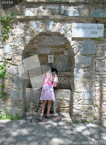 Image of A girl drinks at the spring of Meryemana (Virgin Mary's House)