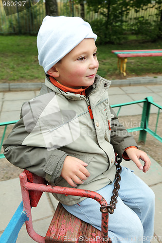 Image of Little boy on rolling swing looking sideways