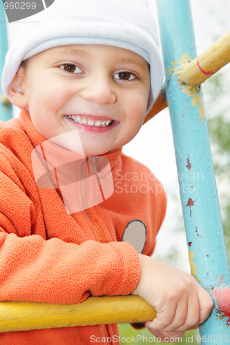 Image of Smiling kid in orange on climbing staircase