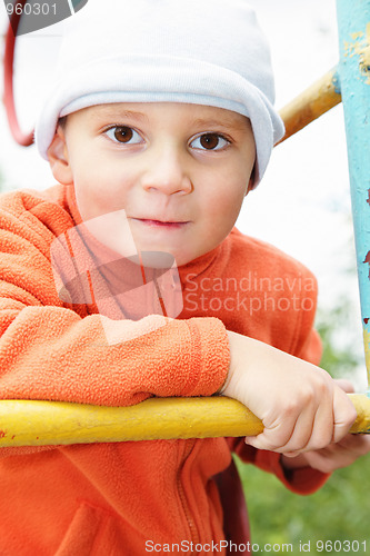 Image of Funny kid in orange on climbing staircase