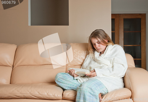 Image of woman reading a book on sofa
