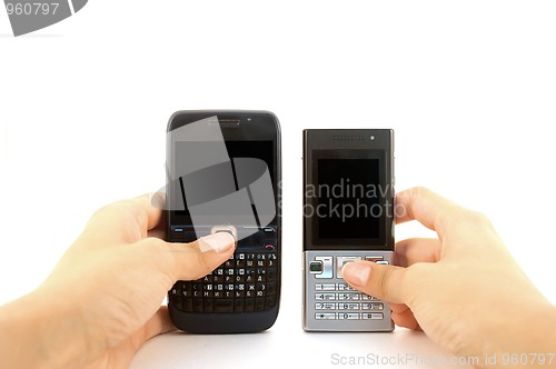 Image of Two mobile phones in hands over white