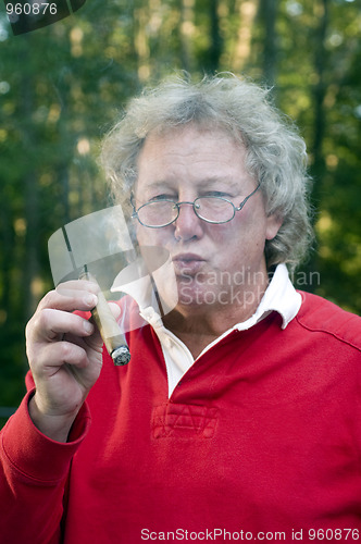 Image of senior man smoking big cigar