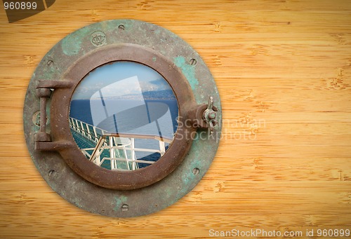 Image of Antique Porthole on Bamboo Wall with View of Ship Deck Railing a