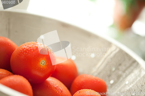 Image of Fresh, Vibrant Roma Tomatoes in Colander with Water Drops