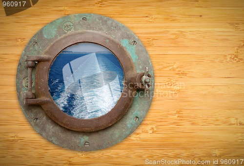 Image of Antique Porthole on Bamboo Wall with View of Ship Ocean Trail