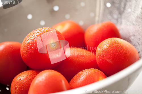 Image of Fresh, Vibrant Roma Tomatoes in Colander with Water Drops