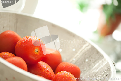 Image of Fresh, Vibrant Roma Tomatoes in Colander with Water Drops