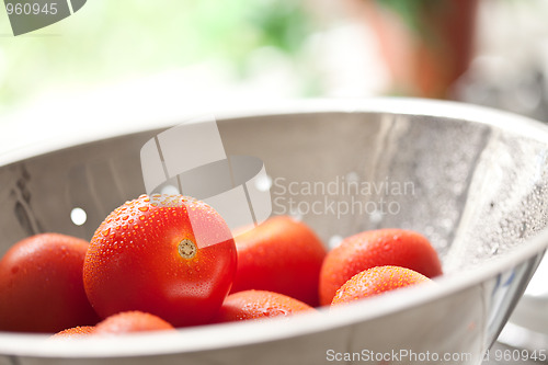 Image of Fresh, Vibrant Roma Tomatoes in Colander with Water Drops
