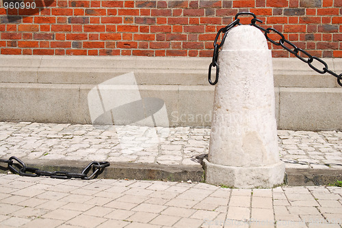 Image of ancient rusty chain and stone column