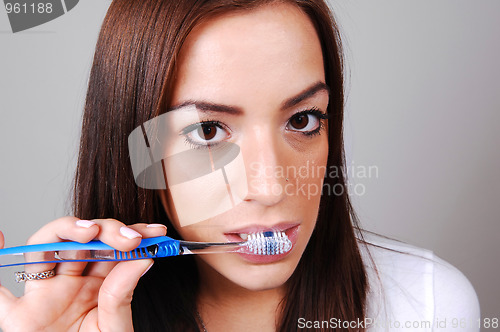 Image of Woman brushing her teeth.