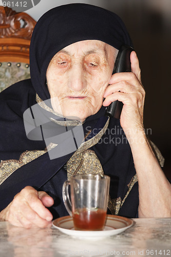 Image of Elderly woman with tea and phone