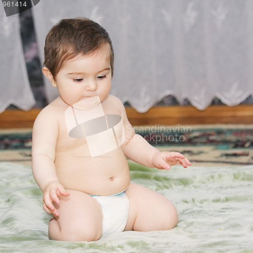 Image of Baby sitting on green carpet