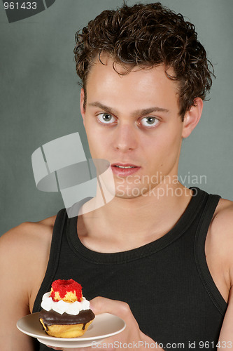Image of Young man with cupcake