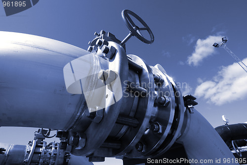 Image of industrial pipelines on pipe-bridge against blue sky 