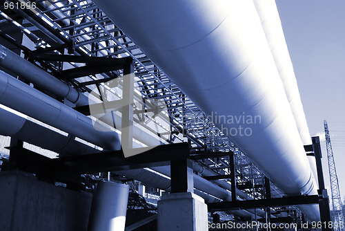 Image of industrial pipelines on pipe-bridge against blue sky 