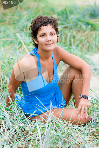 Image of brunet woman sitting in a grass