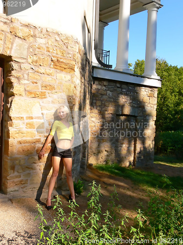 Image of Blond lady on an stone wall.