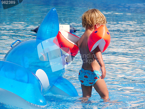 Image of Little boy playing in swimming pool