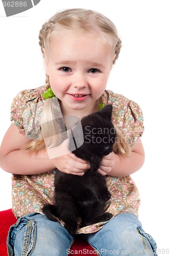 Image of Little girl playing with kitten