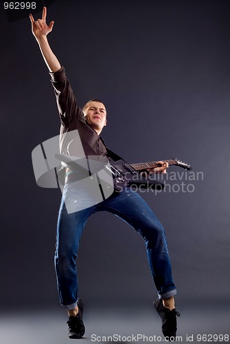 Image of  guitarist  making a rock gesture 