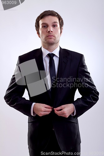Image of business man buttoning his coat