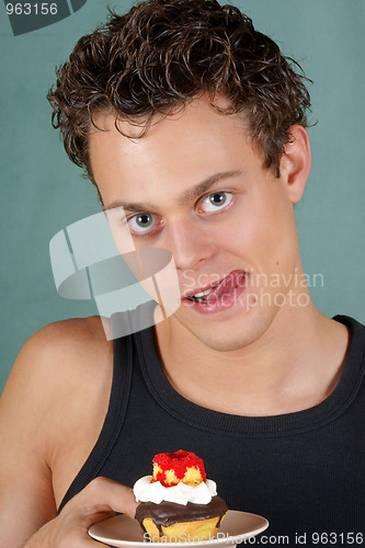 Image of Greedy young man with cupcake