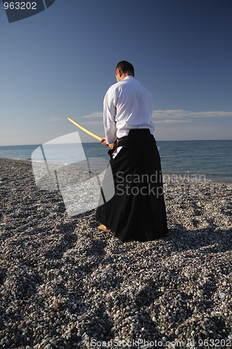 Image of Man exercising with sword rear view
