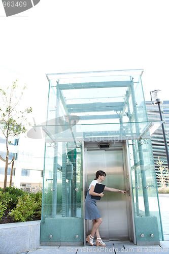 Image of businesswoman waiting for the elevator